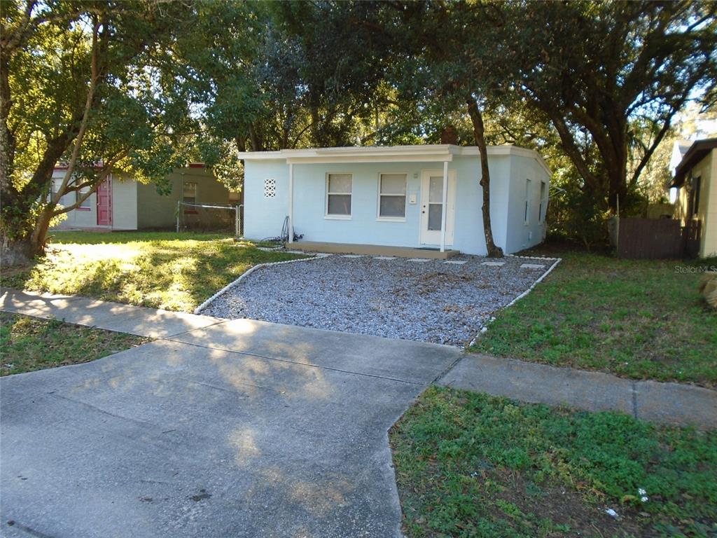 A light blue, single-story house features a gravel driveway and a small front porch — 131 LEMON LANE, CASSELBERRY, FL