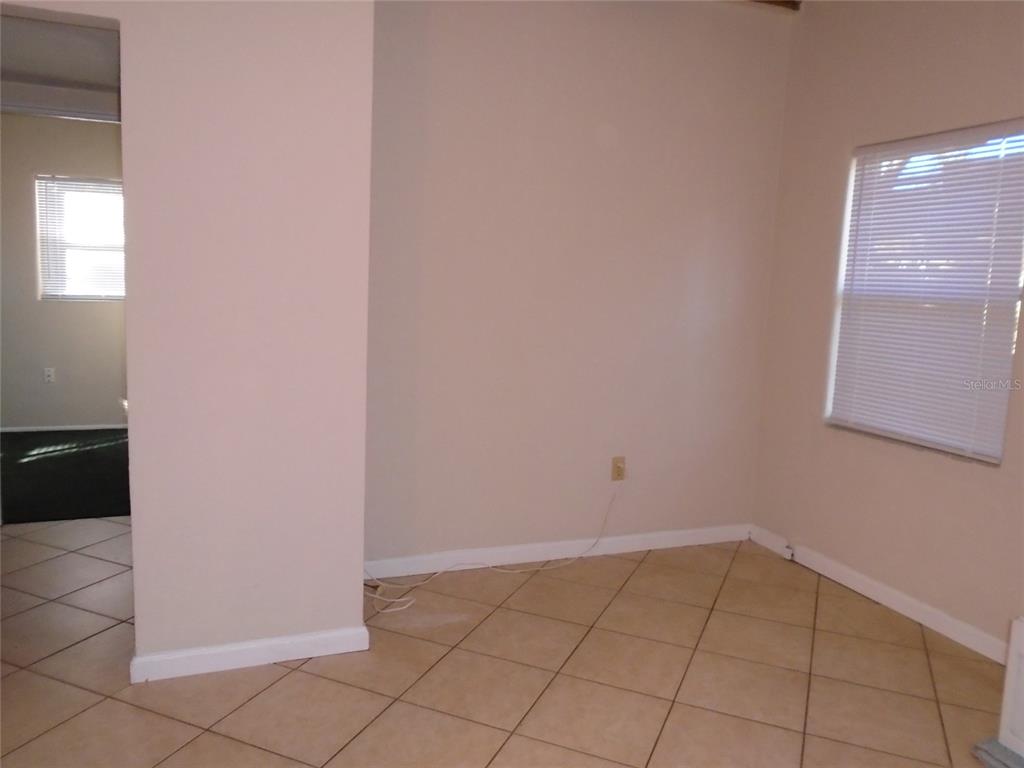 An interior room features beige walls, light-colored tile flooring, and two windows with blinds — 131 LEMON LANE, CASSELBERRY, FL