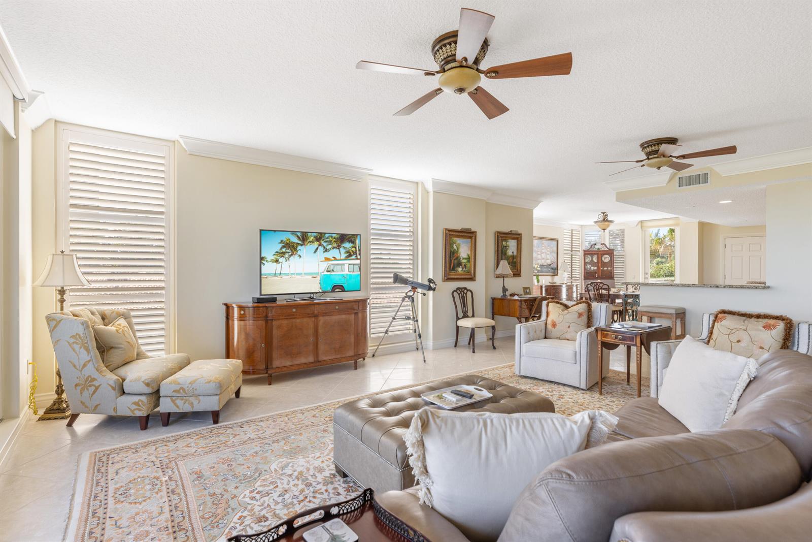 A bright living room features a large television, a leather ottoman, and a patterned rug — HUTCHINSON ISLAND, FL