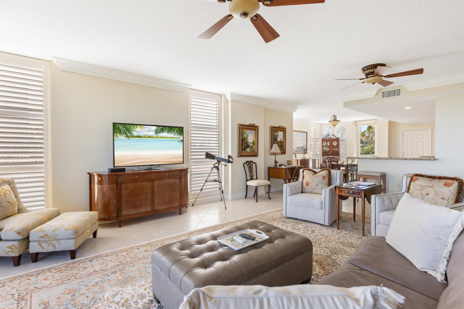 A living room features a television on a wooden console, a leather ottoman, and furniture — HUTCHINSON ISLAND, FL