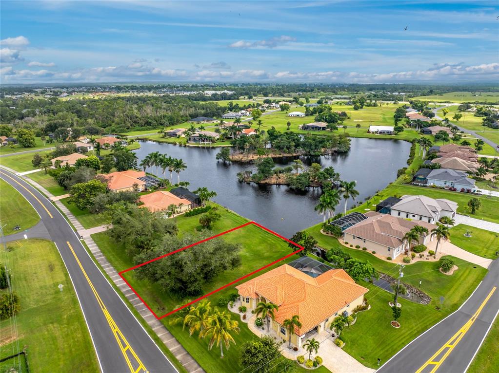 An aerial view shows a vacant lot outlined in red next to a waterfront house — 17204 CAPE HORN BOULEVARD, PUNTA GORDA, FL