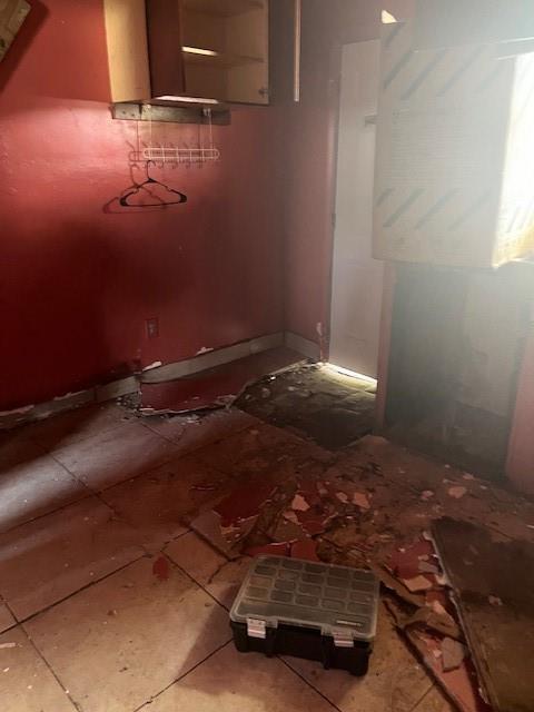 A room with red walls, tiled flooring, a wall-mounted rack, and debris on the floor — 2956 NW 49th Street, Miami FL 33142, MIAMI, FL