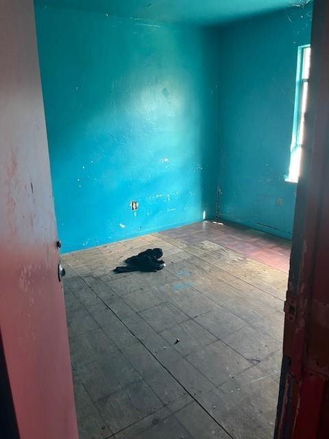 An empty room features bright blue walls, exposed wooden subflooring, and a single window — 2956 NW 49th Street, Miami FL 33142, MIAMI, FL