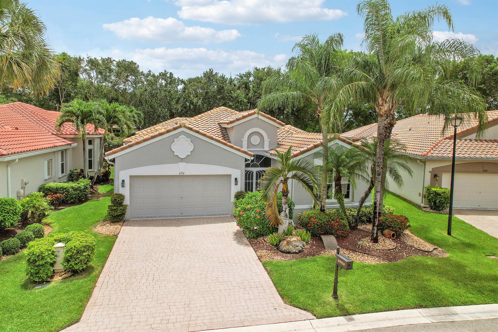 A single-story suburban house with a tiled roof, two-car garage, and landscaped front yard — 6554 Pavone Street, Lake Worth FL 33467, LAKE WORTH, FL