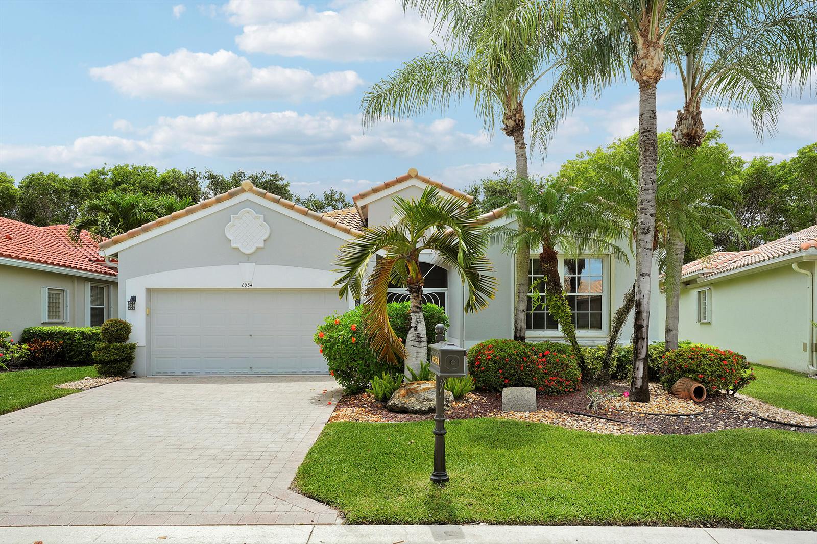 A single-story house with a gray exterior, a two-car garage, and palm trees in front — 6554 Pavone Street, Lake Worth FL 33467, LAKE WORTH, FL