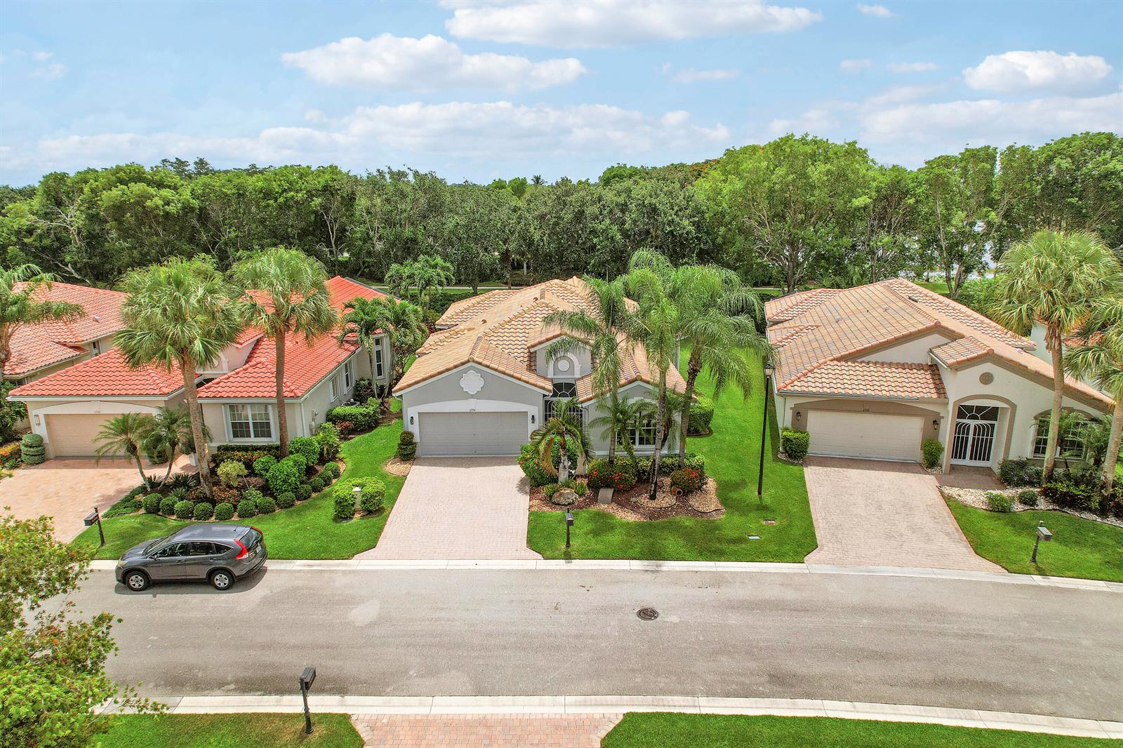 An aerial view shows three suburban houses with tiled roofs and paved driveways — 6554 Pavone Street, Lake Worth FL 33467, LAKE WORTH, FL