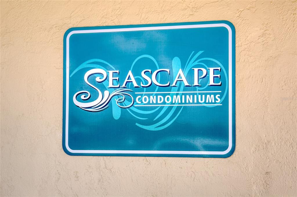 A blue rectangular sign for Seascape Condominiums is mounted on a textured beige wall — 2290 OCEAN SHORE BOULEVARD UNIT 2070, ORMOND BEACH, FL