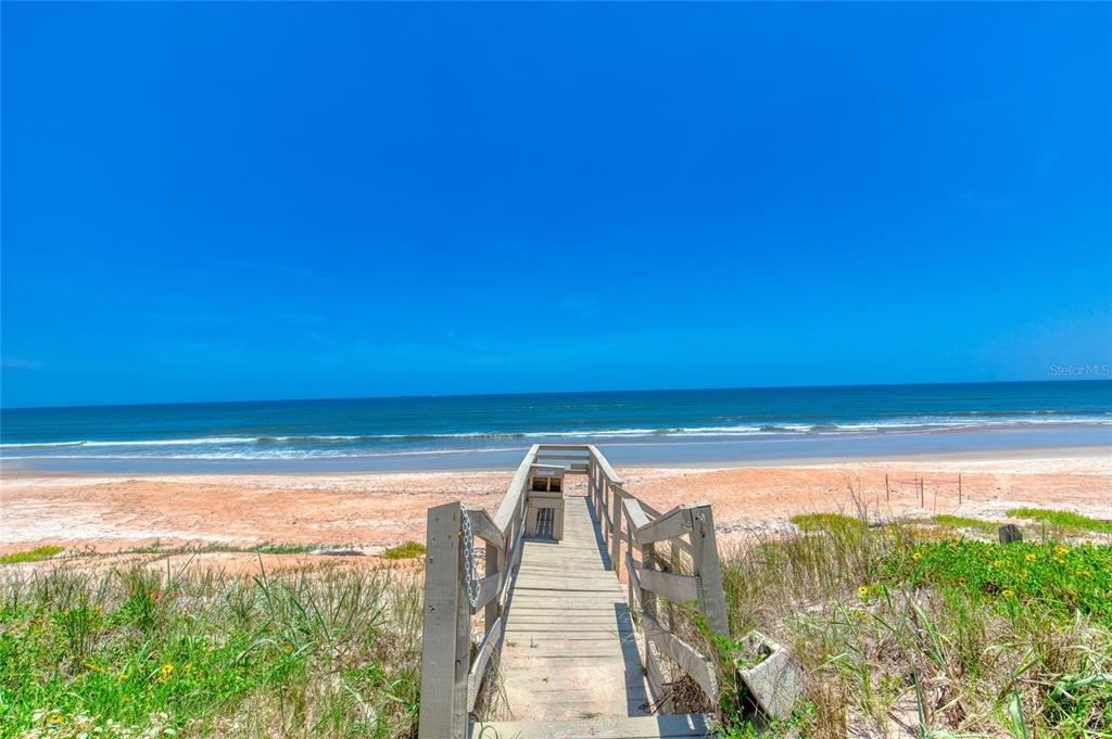A wooden boardwalk leads from a grassy dune area down to a sandy beach — 2290 OCEAN SHORE BOULEVARD UNIT 2070, ORMOND BEACH, FL