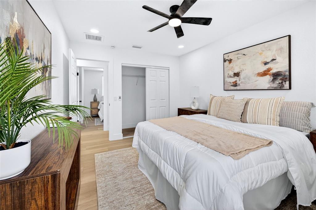 A bedroom features a bed with neutral bedding, a ceiling fan, and a potted plant — 4912 W DRYAD STREET, TAMPA, FL