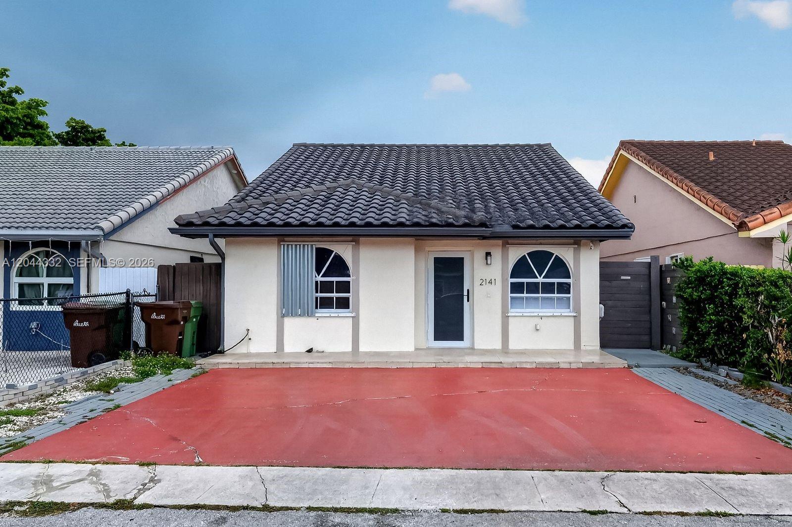A single-story house with a tiled roof, white stucco walls, and a red driveway — 2141 W 53rd St # 1, Hialeah FL 33016, HIALEAH, FL