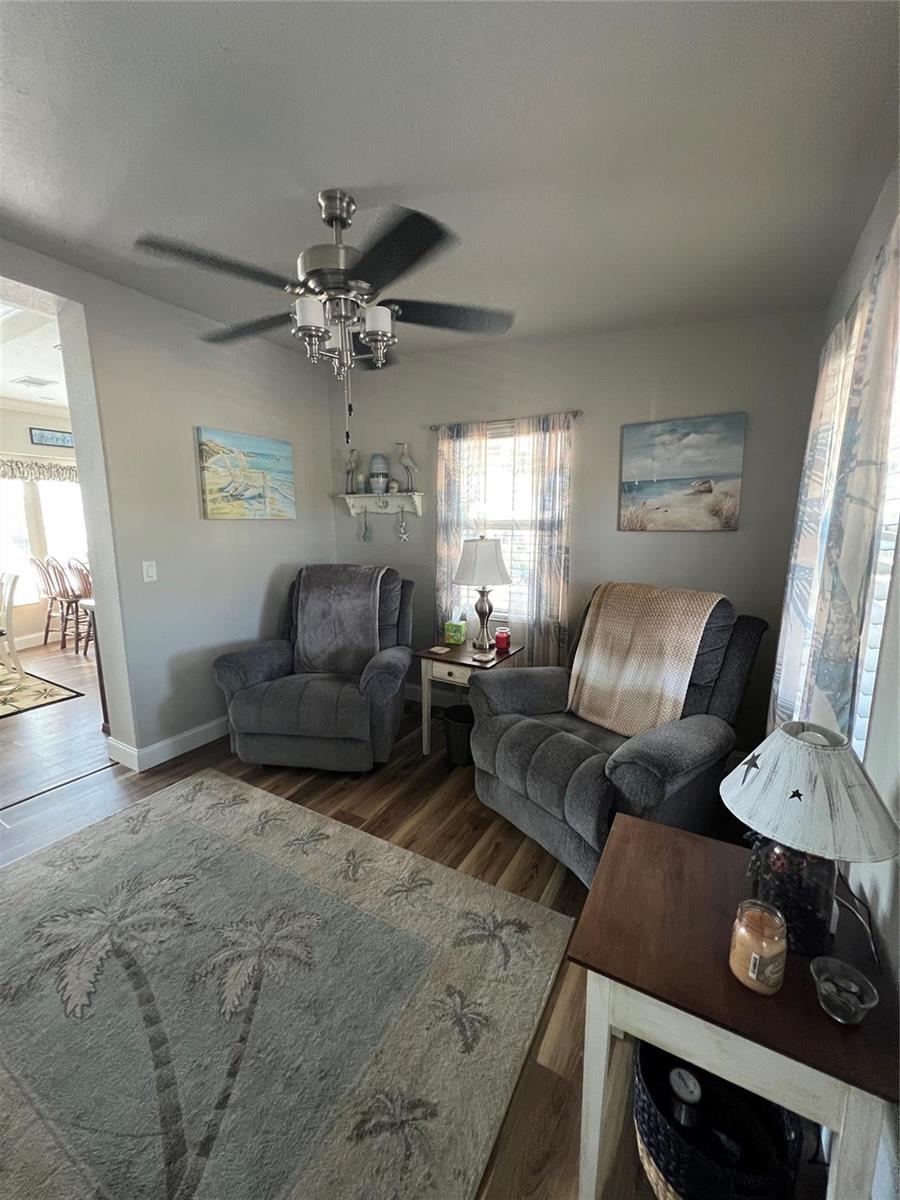 A living room features two gray recliners, a ceiling fan, and a palm tree rug — 6601 SE 51st Street, Okeechobee FL 34974, OKEECHOBEE, FL