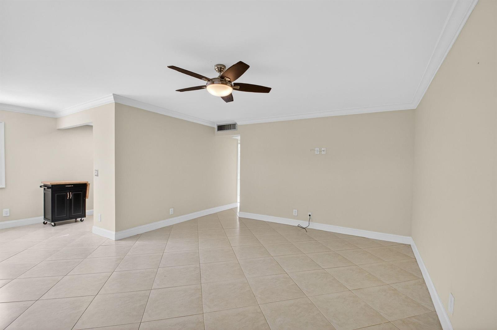 An empty living room features beige walls, light-colored tile flooring, and a ceiling fan — 109 Monaco C # 109, Delray Beach FL 33446, DELRAY BEACH, FL