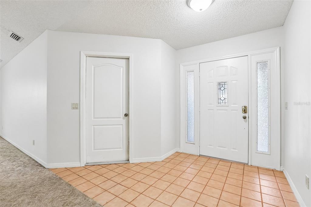A single-story brick house features a two-car garage and a concrete driveway — 6540 FOXMOOR DRIVE, ZEPHYRHILLS, FL