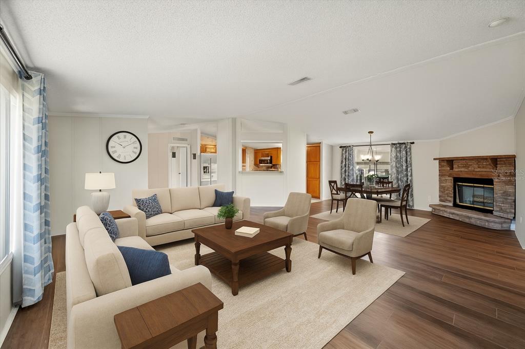 A living room with a stone fireplace, wood-look flooring, and a dining area in back — 101 EDGEWOOD BOULEVARD, LAKE WALES, FL