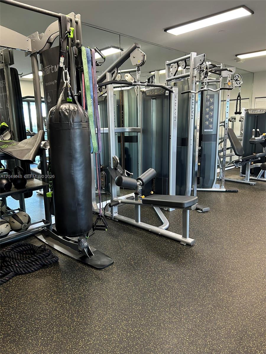 This gym features various weight machines, a punching bag, and rubber flooring — 2625 Collins Ave # 1805, Miami Beach FL 33140, MIAMI BEACH, FL