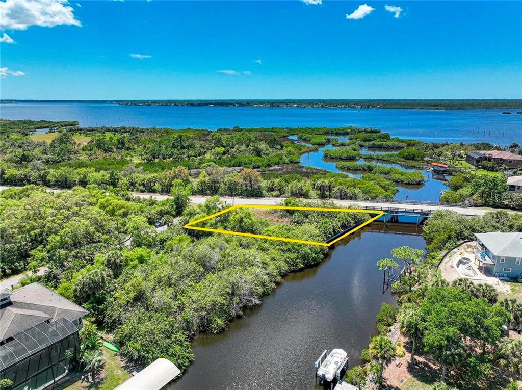 An aerial view shows a vacant, rectangular lot bordered by a canal and a road — 12412 EISENHOWER DRIVE, PORT CHARLOTTE, FL