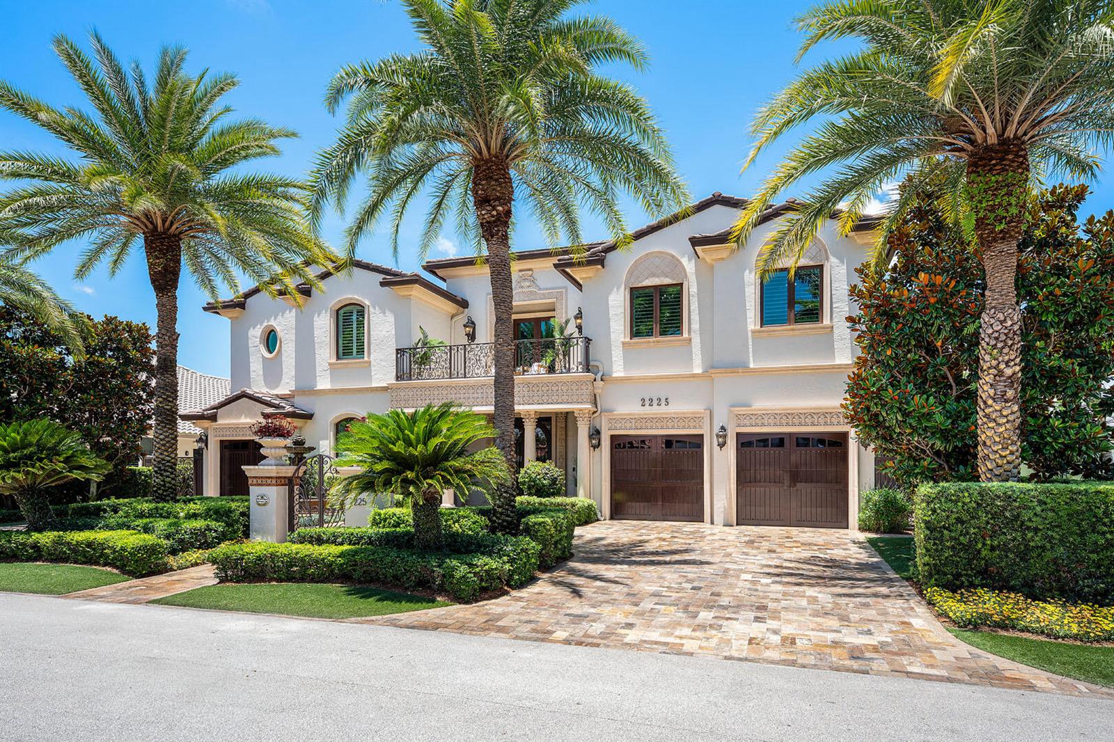 A two-story Mediterranean-style house features a paved driveway, palm trees, and a balcony — 2225 W Silver Palm Road, Boca Raton FL 33432, BOCA RATON, FL