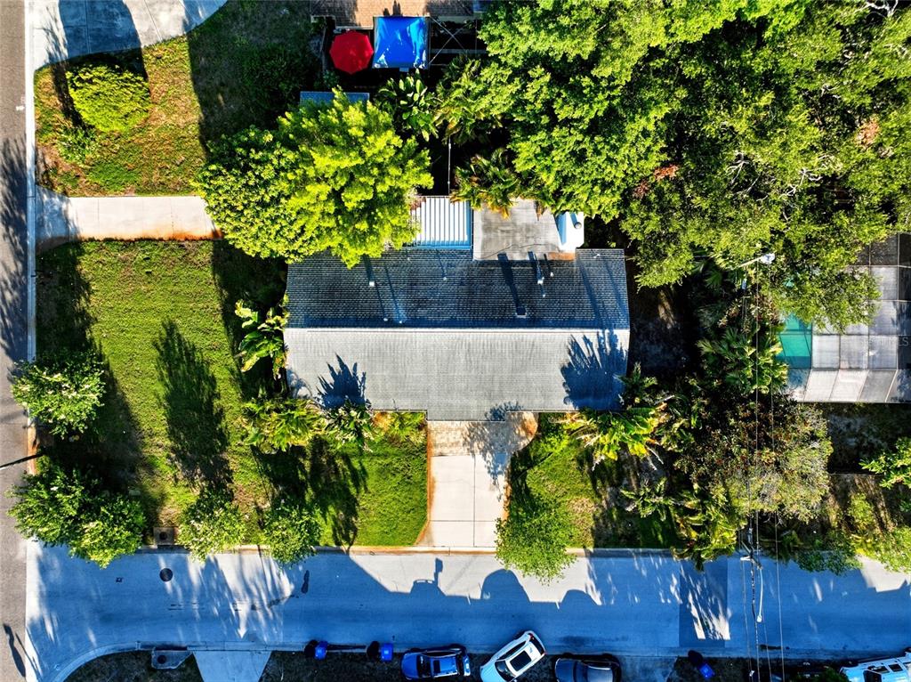 An aerial view shows a single-story house with a gray roof, driveway, and surrounding trees — 2310 29TH STREET N, ST PETERSBURG, FL