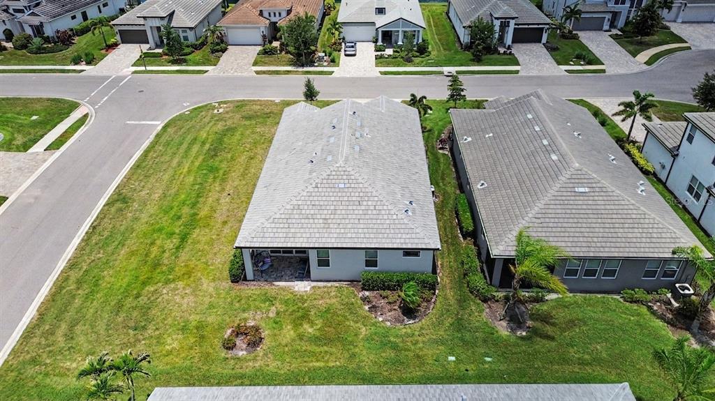 An aerial view shows the back of a suburban house with a covered patio — 12115 BALD CYPRESS COVE, PARRISH, FL