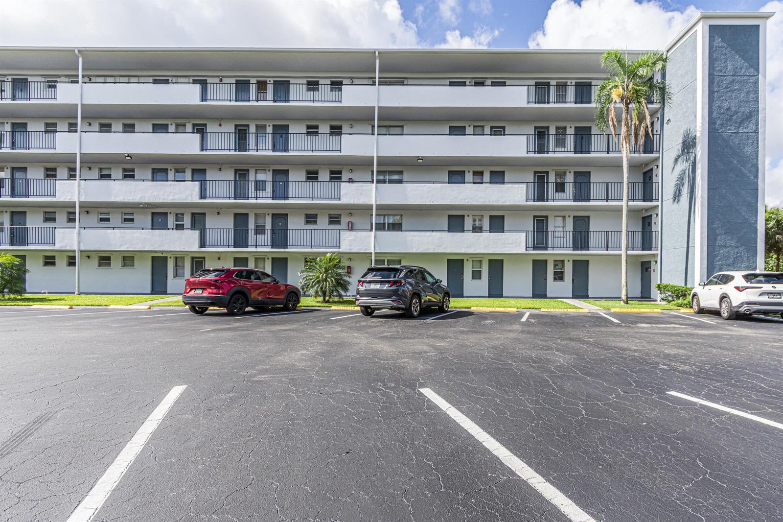 A multi-story apartment building with exterior walkways and a parking lot in the foreground — 950 Hillcrest Drive # 514, Hollywood FL 33021, HOLLYWOOD, FL