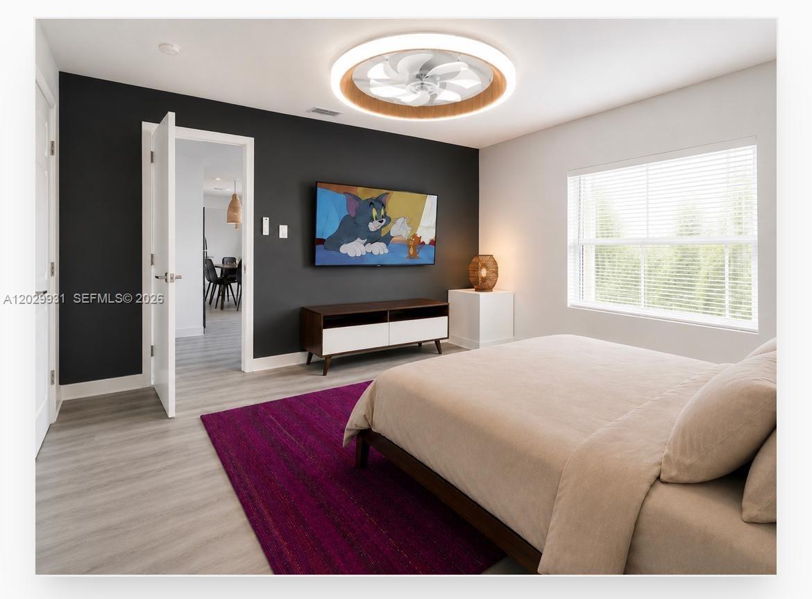 A bedroom features a dark accent wall, a television, a ceiling fan, and a rug — 5519 NW 4th Ave, Miami FL 33127, MIAMI, FL