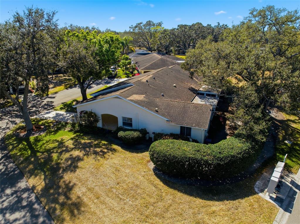An aerial view shows a single-story house with a shingled roof and surrounding landscaping — 2101 HAILSTONE CIRCLE UNIT 0, SUN CITY CENTER, FL