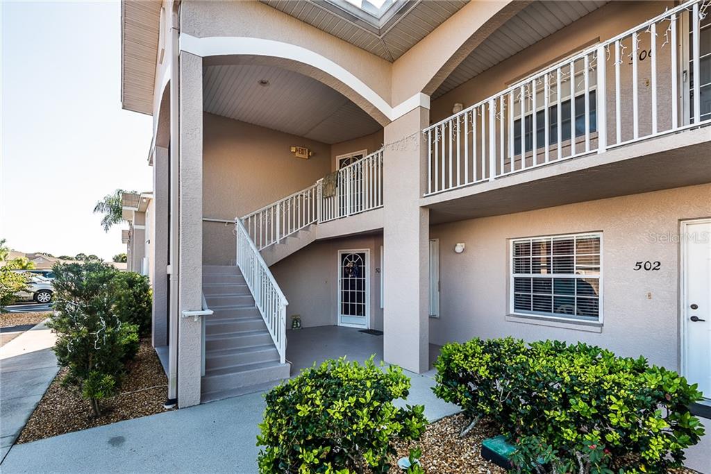 An exterior view of a two-story apartment building with a staircase leading to the upper level — 11644 SW EGRET CIRCLE UNIT 506, LAKE SUZY, FL