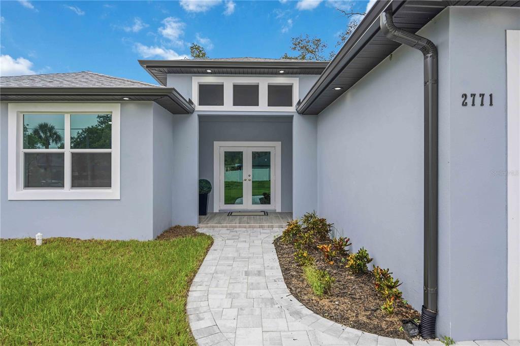 The exterior of a house features a paved walkway leading to a double-door entryway — 2771 HALLADAY STREET, NORTH PORT, FL