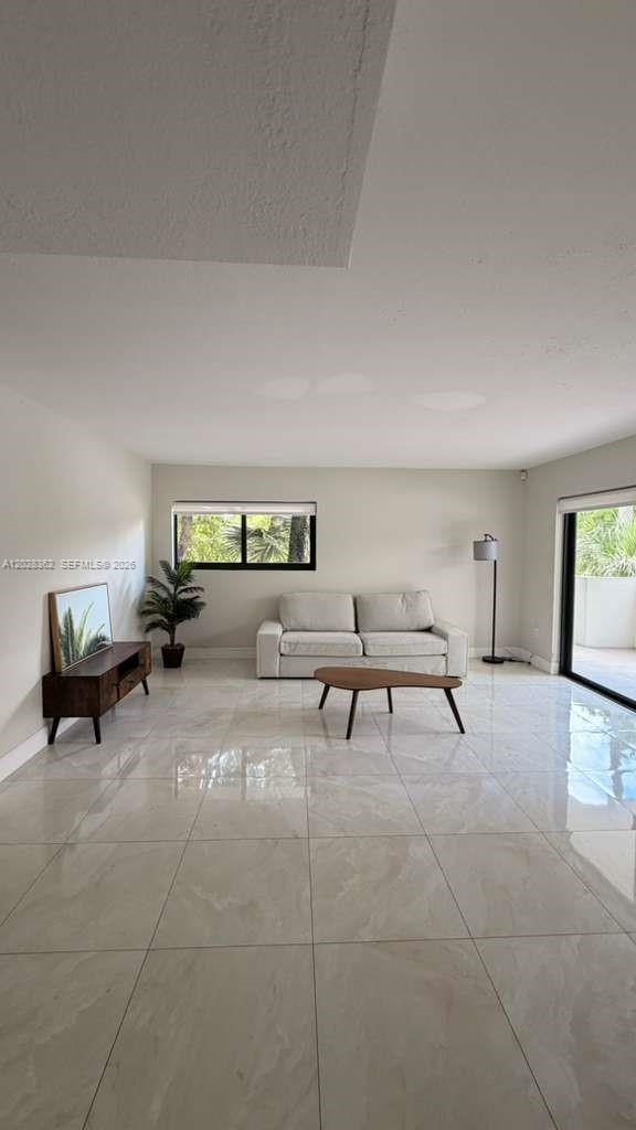 A living room with light tile floors, a sofa, a coffee table, and a media console — 800 S Dixie Hwy 203 Hwy # 203, Coral Gables FL 33146, CORAL GABLES, FL