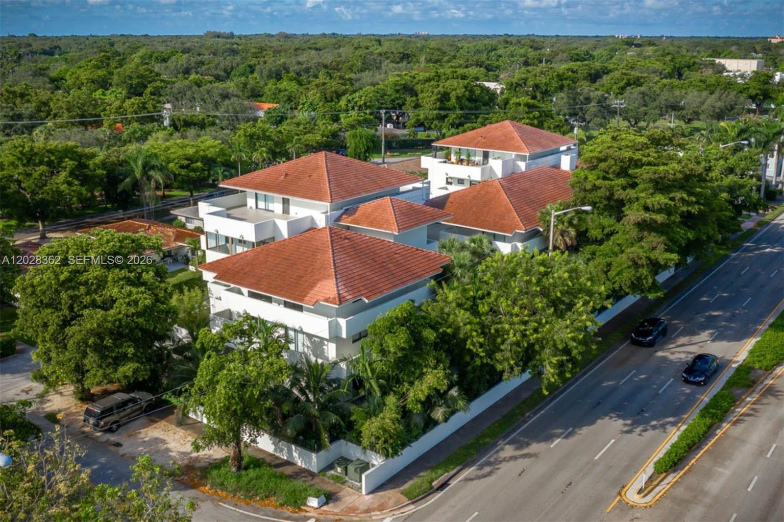 An aerial view shows a multi-story white building with red tile roofs near a road — 800 S Dixie Hwy 203 Hwy # 203, Coral Gables FL 33146, CORAL GABLES, FL