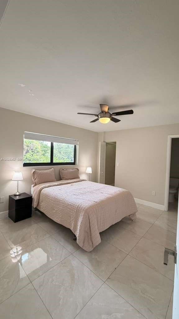 A bedroom with light-colored tile floors, a ceiling fan, and a bed with beige bedding — 800 S Dixie Hwy 203 Hwy # 203, Coral Gables FL 33146, CORAL GABLES, FL