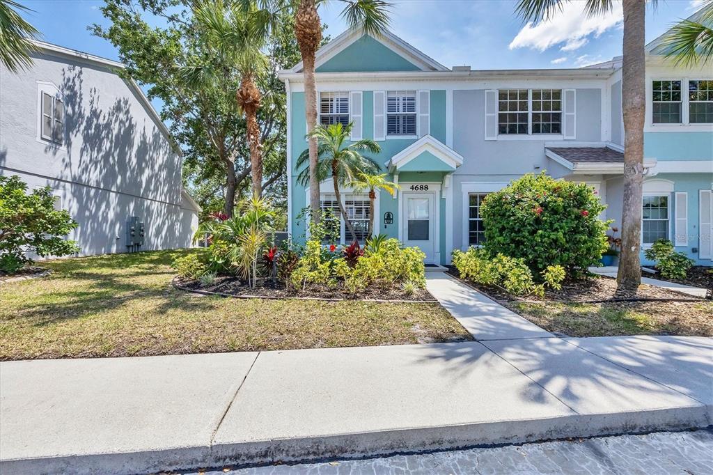 A two-story teal and light blue townhouse with a front walkway and palm trees — 4688 SABAL KEY DRIVE, BRADENTON, FL