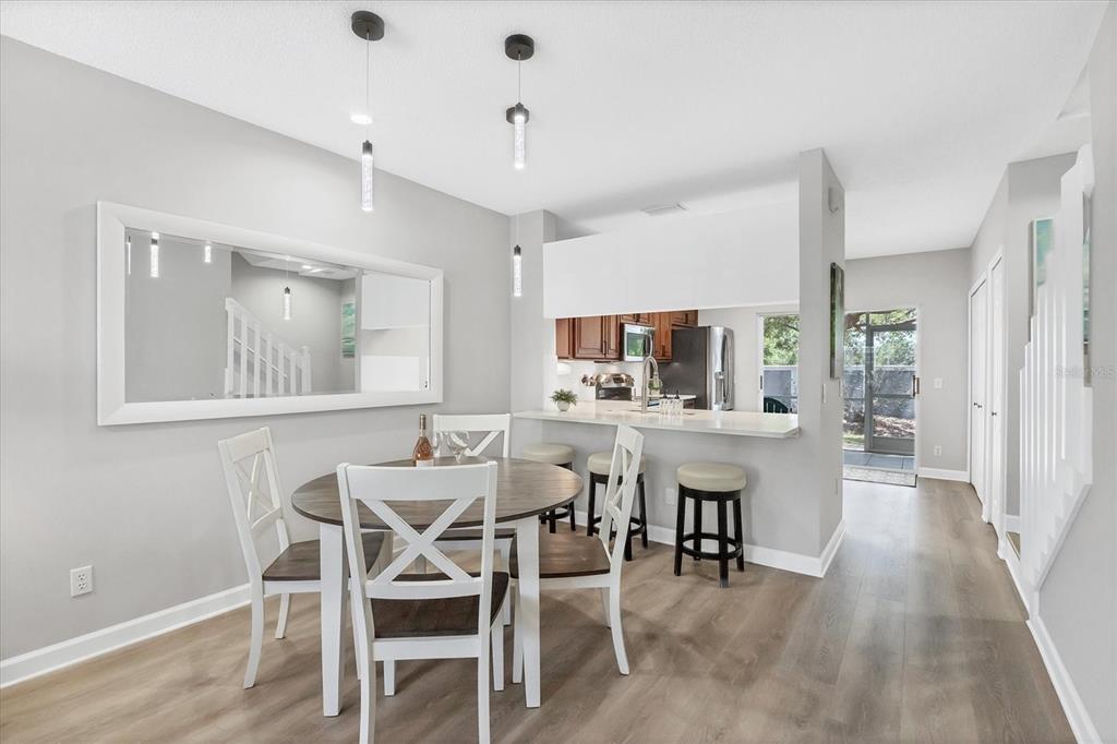 A dining area with a round table, white chairs, and a breakfast bar with stools — 4688 SABAL KEY DRIVE, BRADENTON, FL