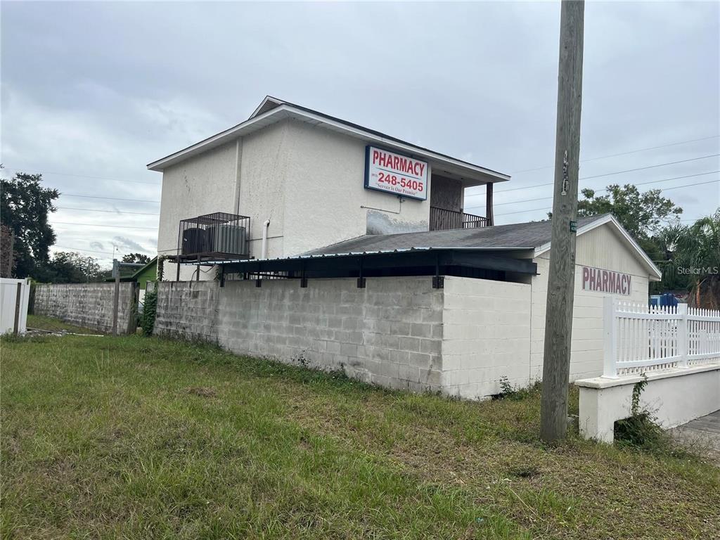 A two-story building with a pharmacy sign and a concrete block wall exterior — 3302 E DR MARTIN LUTHER KING JR BOULEVARD, TAMPA, FL