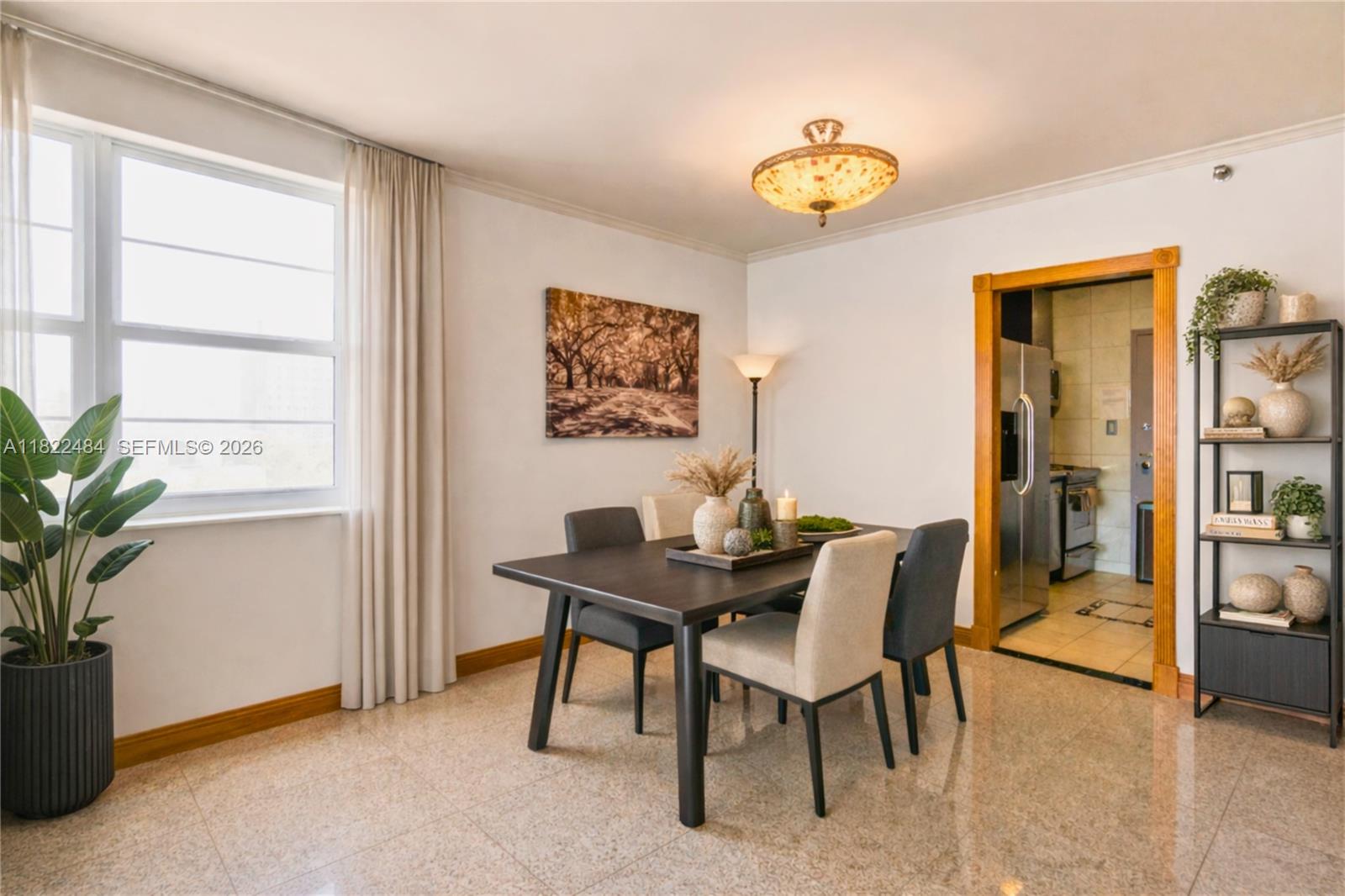 A dining room features a dark table, four chairs, tile flooring, and a window — 100 Lincoln Rd # 811, Miami Beach FL 33139, MIAMI BEACH, FL