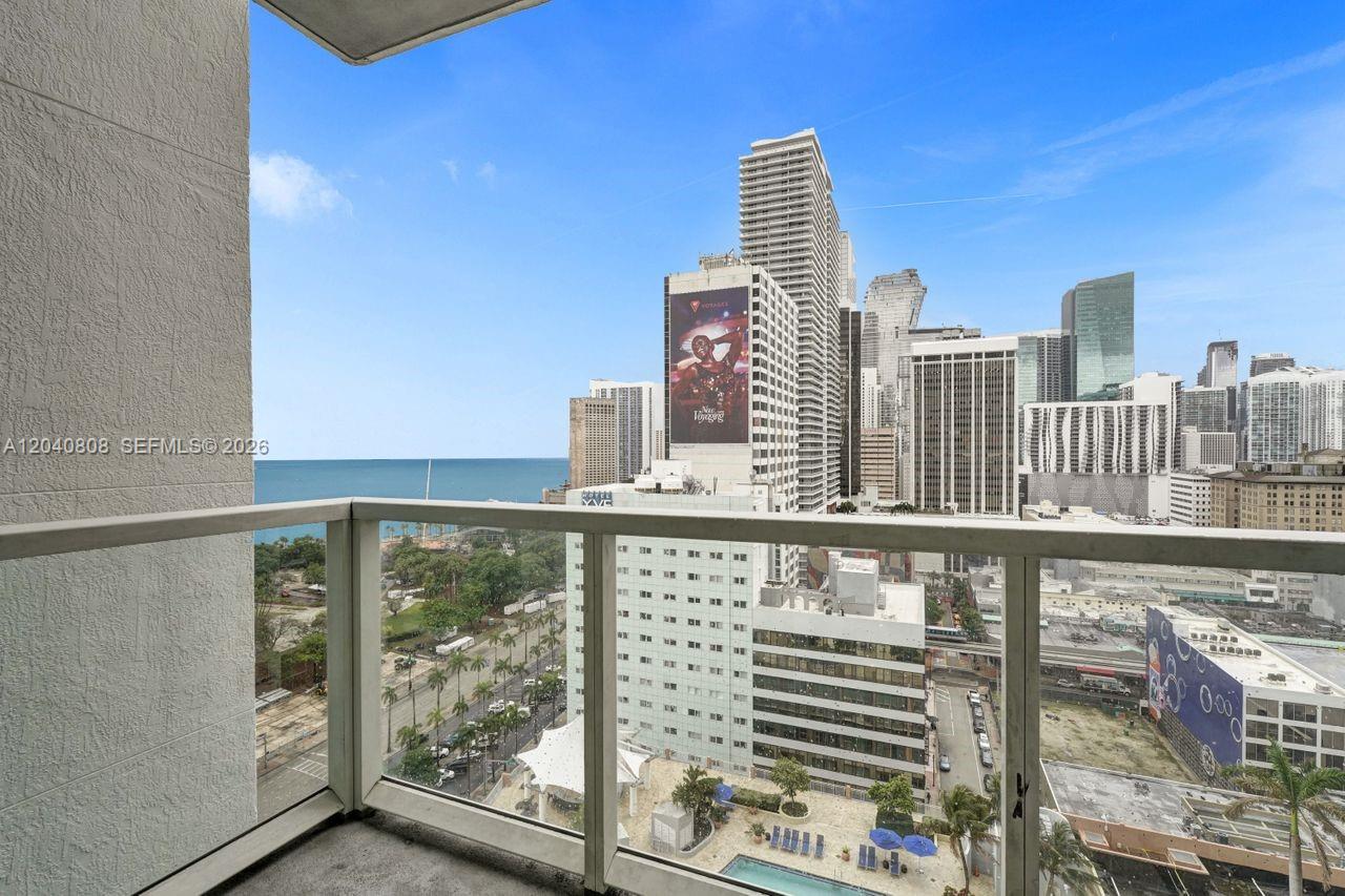 A balcony view overlooks a city skyline, a swimming pool, and the ocean — 244 Biscayne Blvd # 2005, Miami FL 33132, MIAMI, FL