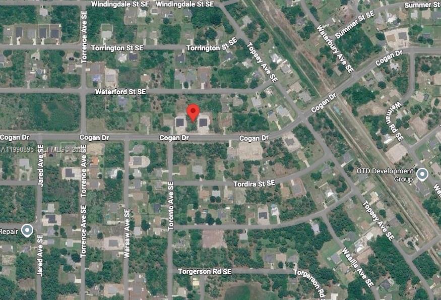 This is a satellite map view showing a residential area with a red location pin — 2065 SE Cogan Dr, Palm Bay FL 32909, PALM BAY, FL