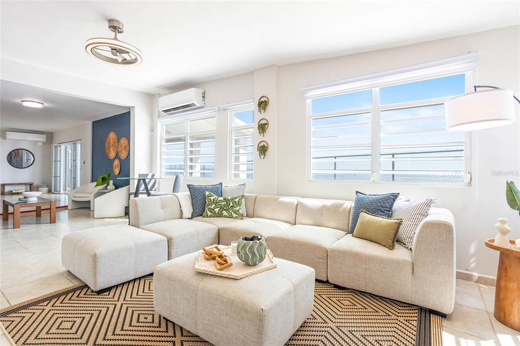 A bright living room features a large beige sectional sofa, a matching ottoman, and tile flooring — 14-2 CAMINO LAS PICUAS, RIO GRANDE, PR