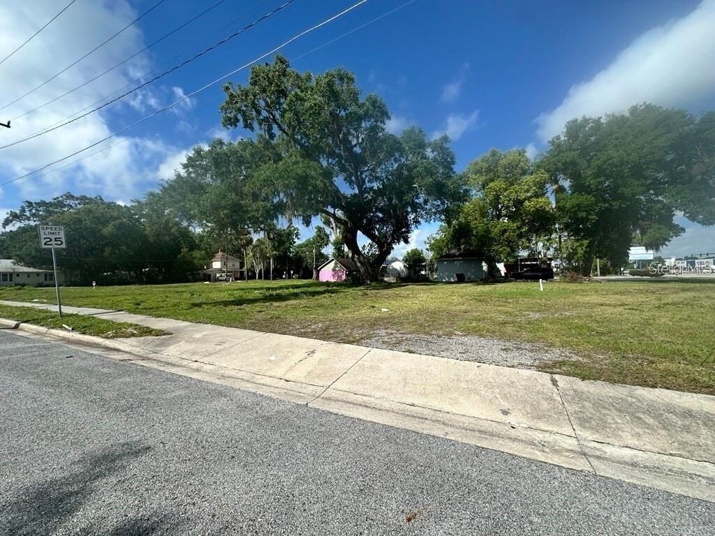 A vacant, grassy lot features a large tree and a speed limit sign — 1314 BRACK STREET, KISSIMMEE, FL