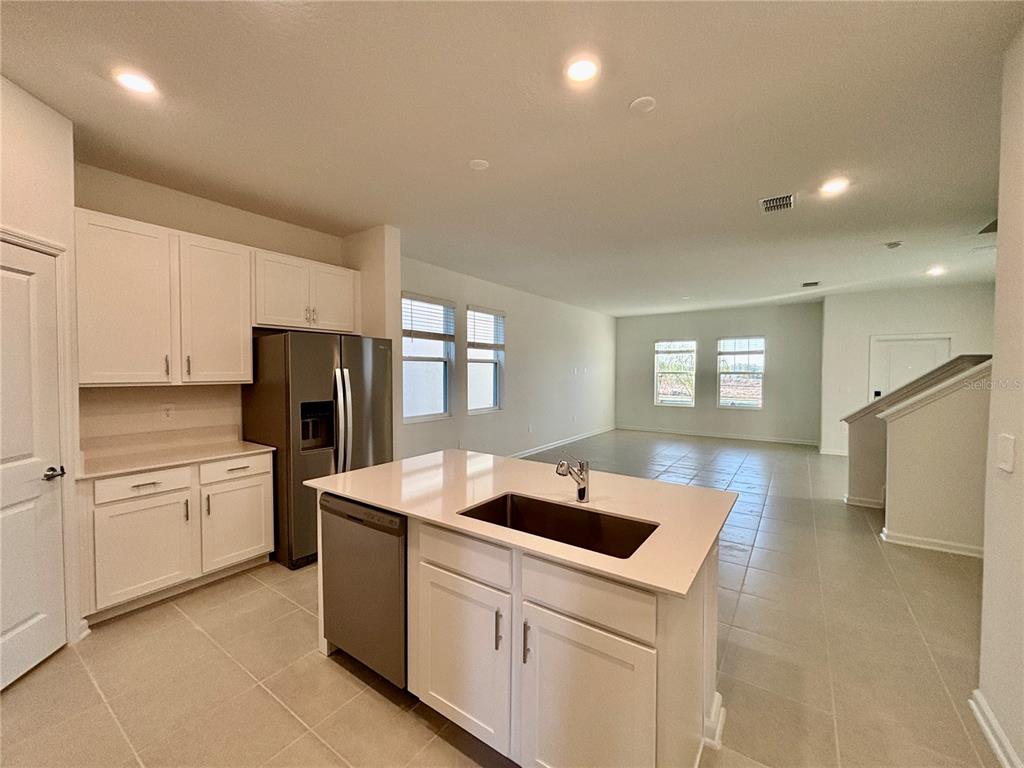 A kitchen with white cabinets, a center island with a sink, and tile flooring — 5770 MEDITATION DRIVE, CLERMONT, FL