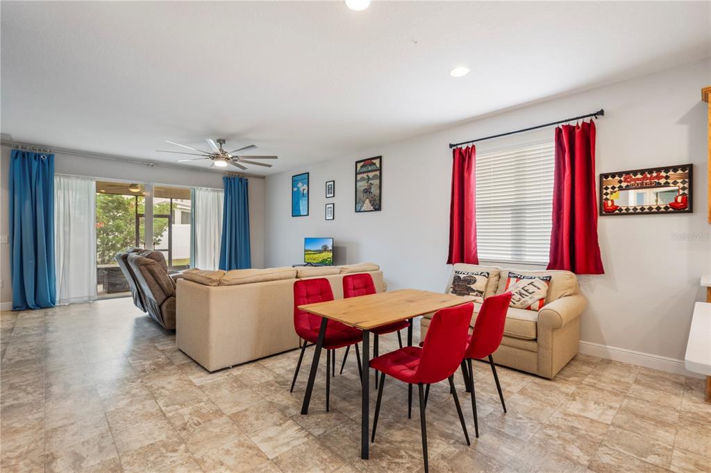 A living and dining area features tile flooring, red chairs, and a beige sectional sofa — 390 CASA VERANO LANE, DAVENPORT, FL