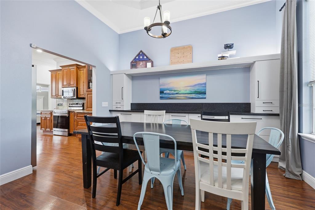 A living room with a large gray sectional sofa, hardwood floors, and an open kitchen — 25672 NW 173RD AVENUE, HIGH SPRINGS, FL