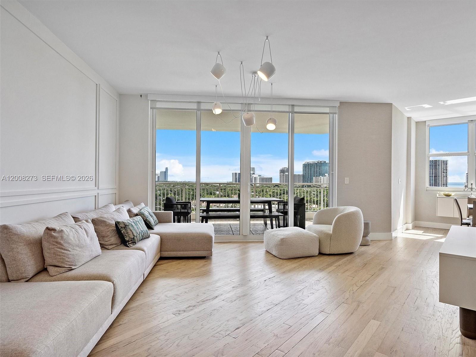 A living room features light wood floors, a large sectional sofa, and a balcony view — 9751 E Bay Harbor Dr # 11A, Bay Harbor Islands FL 33154, BAY HARBOR ISLANDS, FL