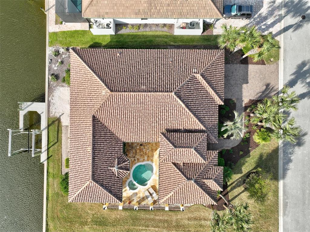 An aerial view shows a house with a tiled roof, a courtyard pool, and a dock — 88 HIDDEN COVE, FLAGLER BEACH, FL