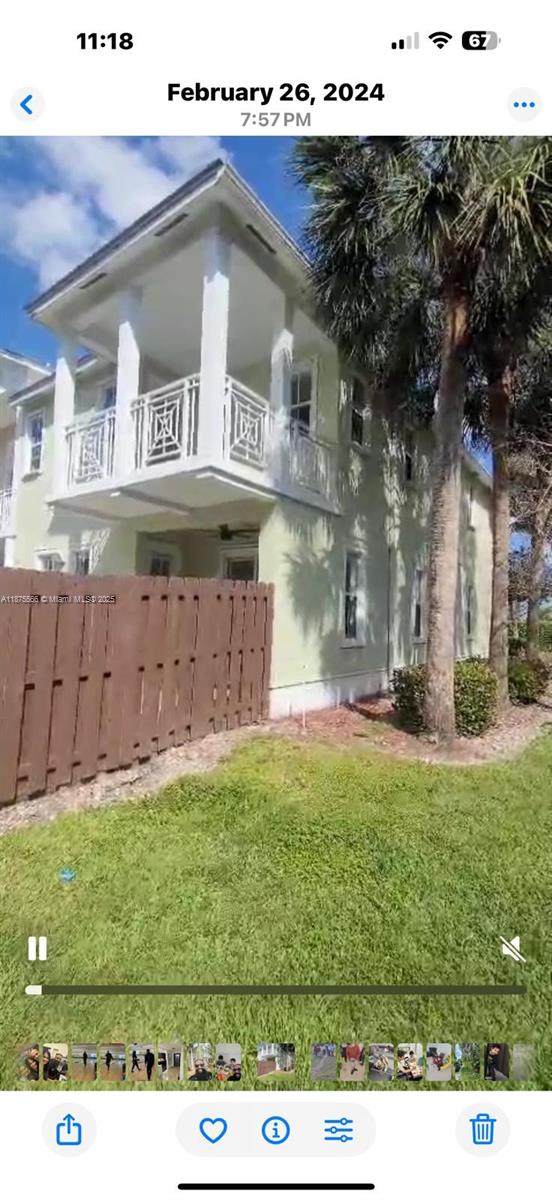 A two-story house with a light green exterior, a white balcony, and a wooden fence — 7414 NW 107th Ct, Doral FL 33178, DORAL, FL
