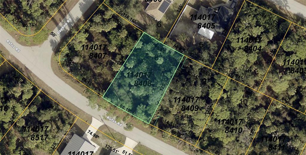 This is an aerial map showing a highlighted vacant lot among surrounding wooded properties — RUFUS ROAD, NORTH PORT, FL