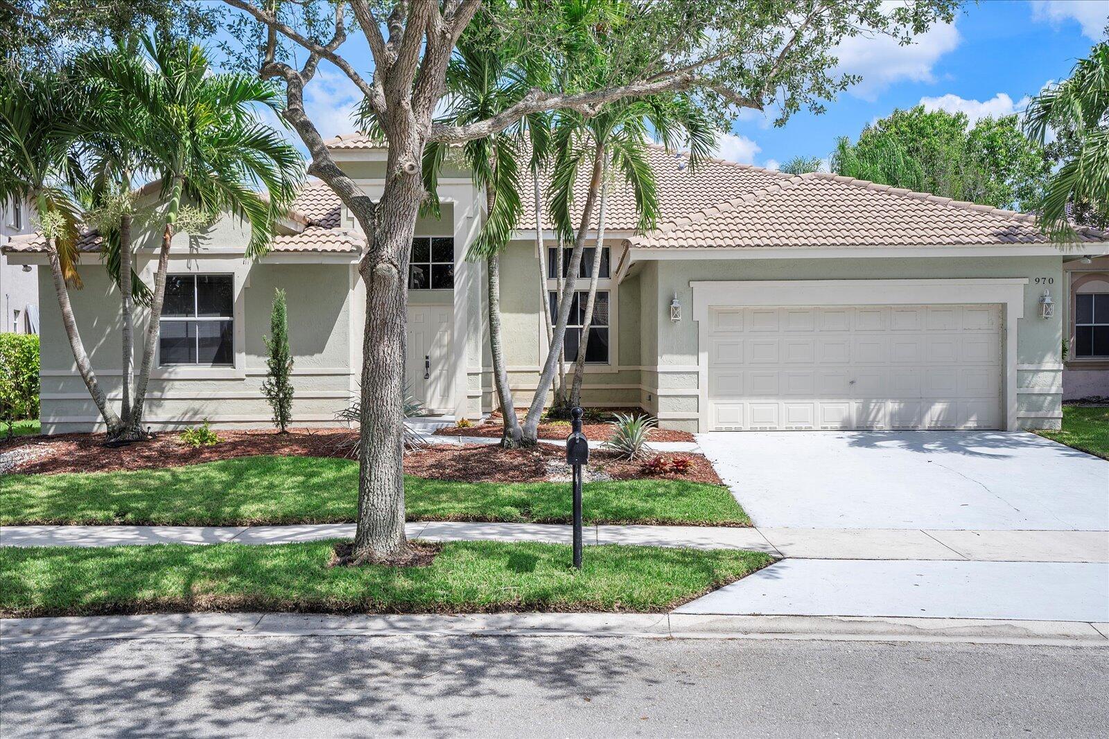 A one-story suburban house with a tile roof, two-car garage, and palm trees in front — 970 Greenwood Road, Weston FL 33327, WESTON, FL