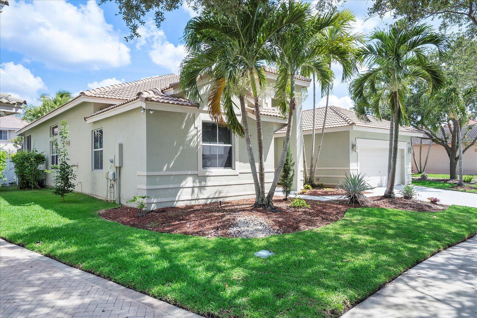 A single-story house with a light green exterior, tile roof, and palm trees in front — 970 Greenwood Road, Weston FL 33327, WESTON, FL