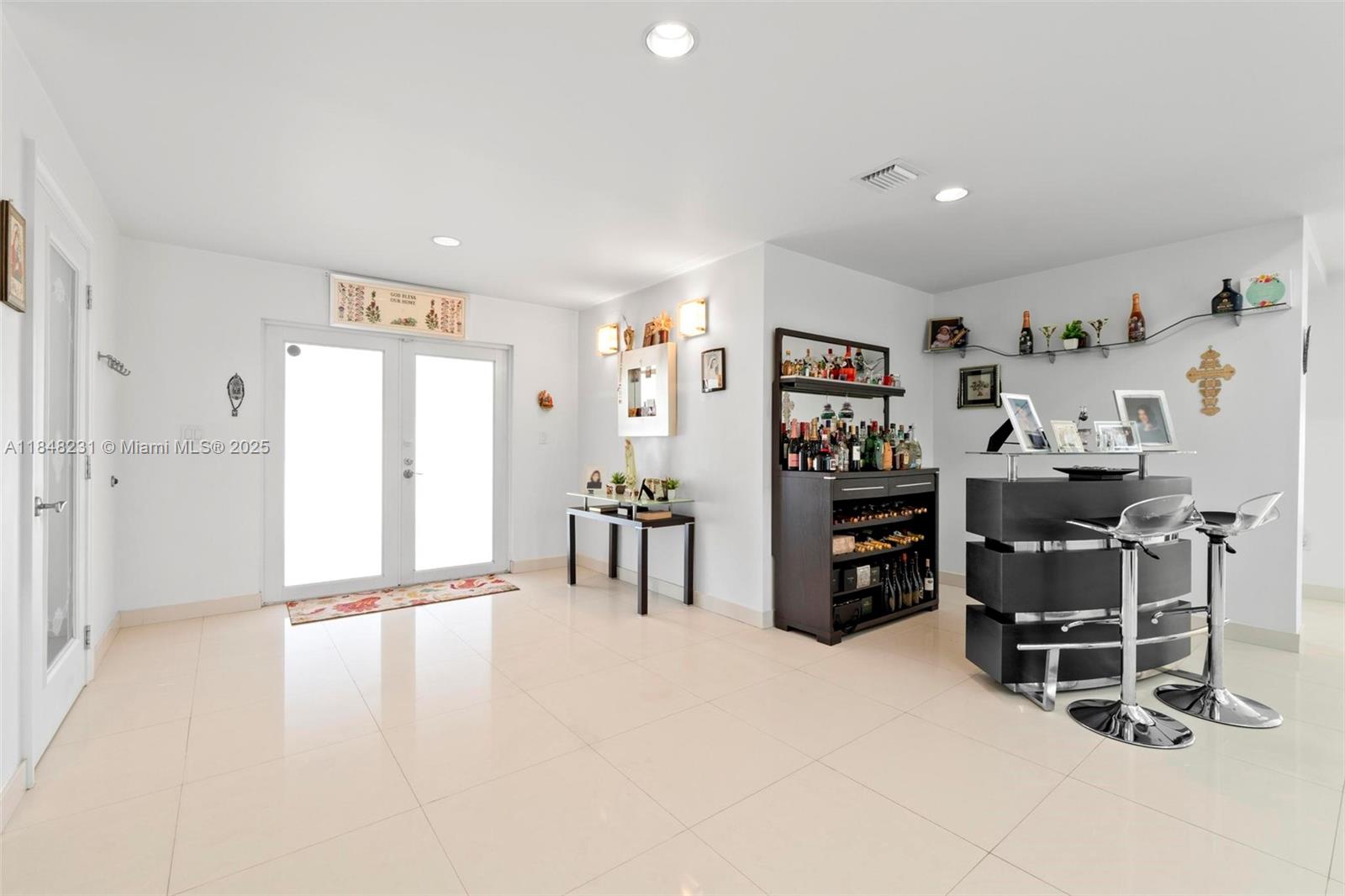 A bright room features white tile floors, a double-door entrance, and a modern home bar — 5045 SW 67th Ave, South Miami FL 33155, SOUTH MIAMI, FL