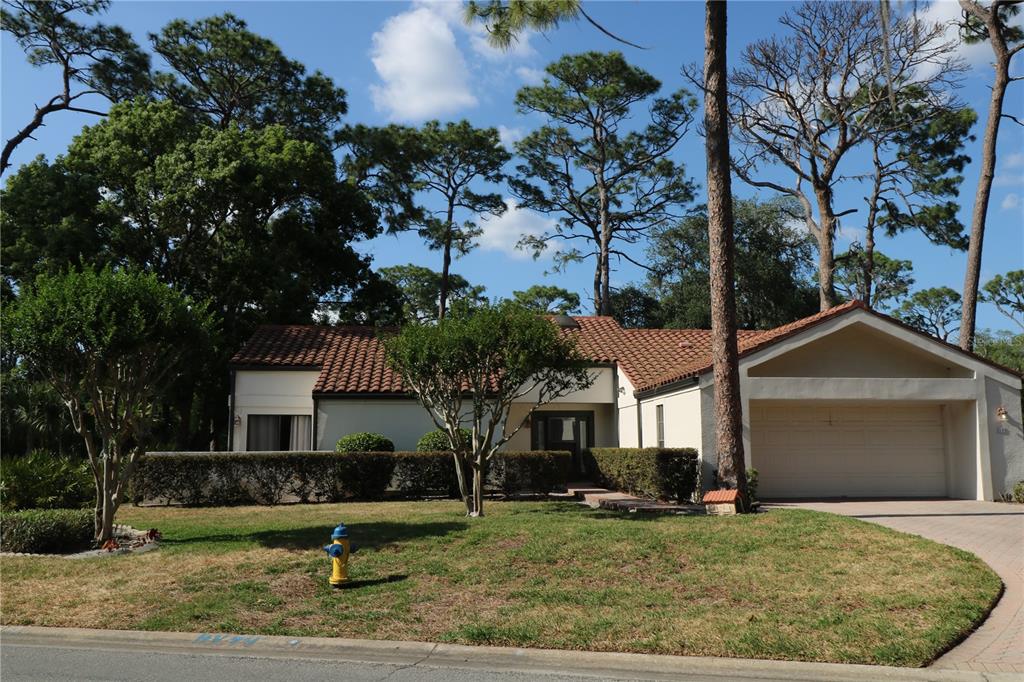 A single-story house with a tile roof, attached garage, and a fire hydrant on the lawn — 5424 SADDLEBROOK WAY, WESLEY CHAPEL, FL
